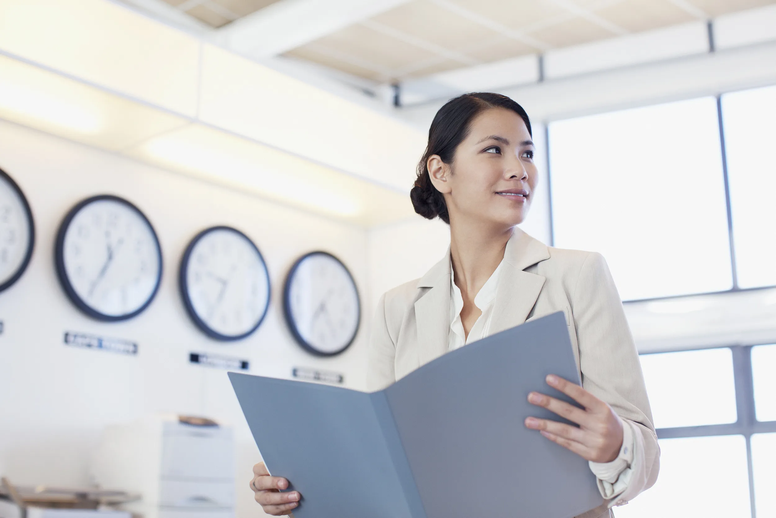 Young contemplative businesswoman sitting on office desk