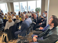 An engaged audience listens, as the City is seen in the background Thumbnail of An engaged audience listens, as the City is seen in the background