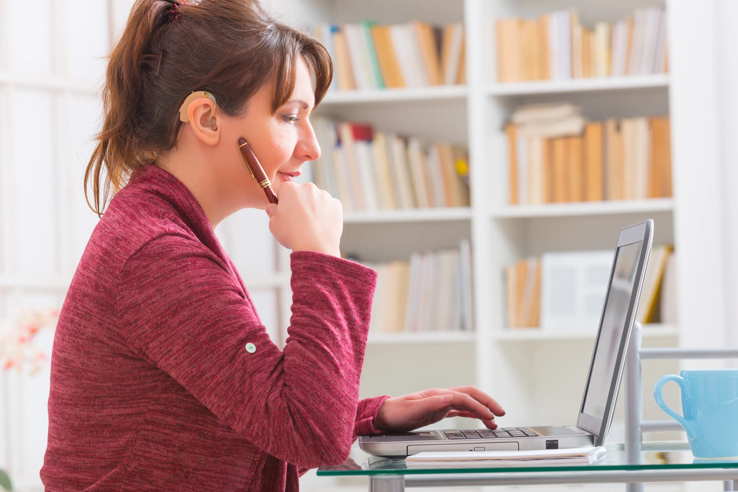 Hearing impaired woman working at laptop