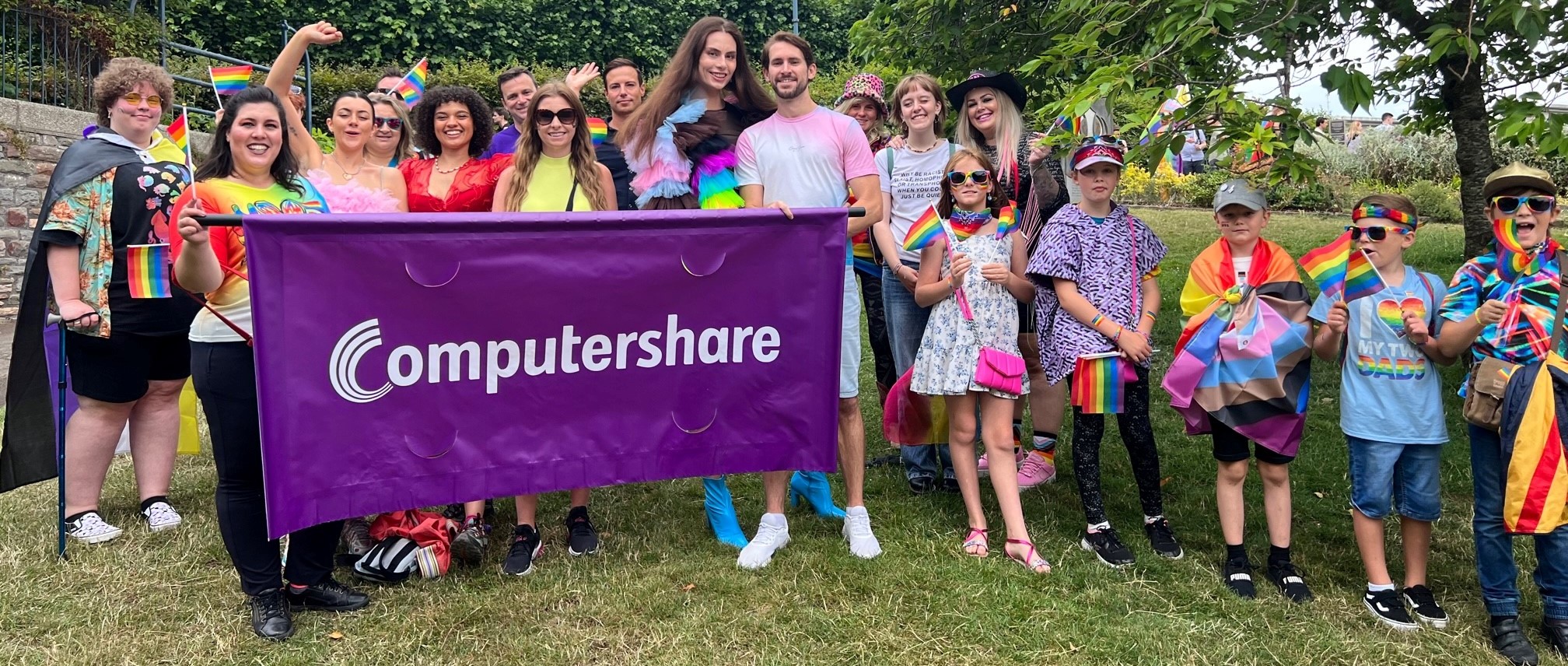 A group celebrating pride with a Computershare banner