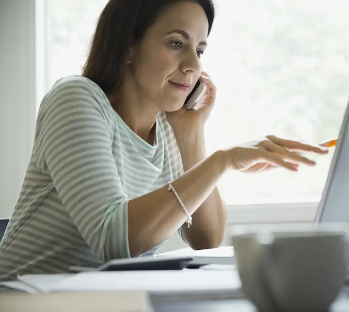 Businesswoman using technologies at desk in home office