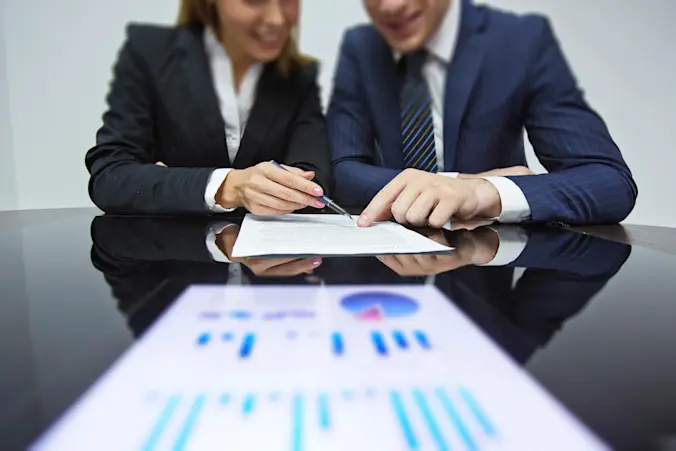 Two people looking at a report