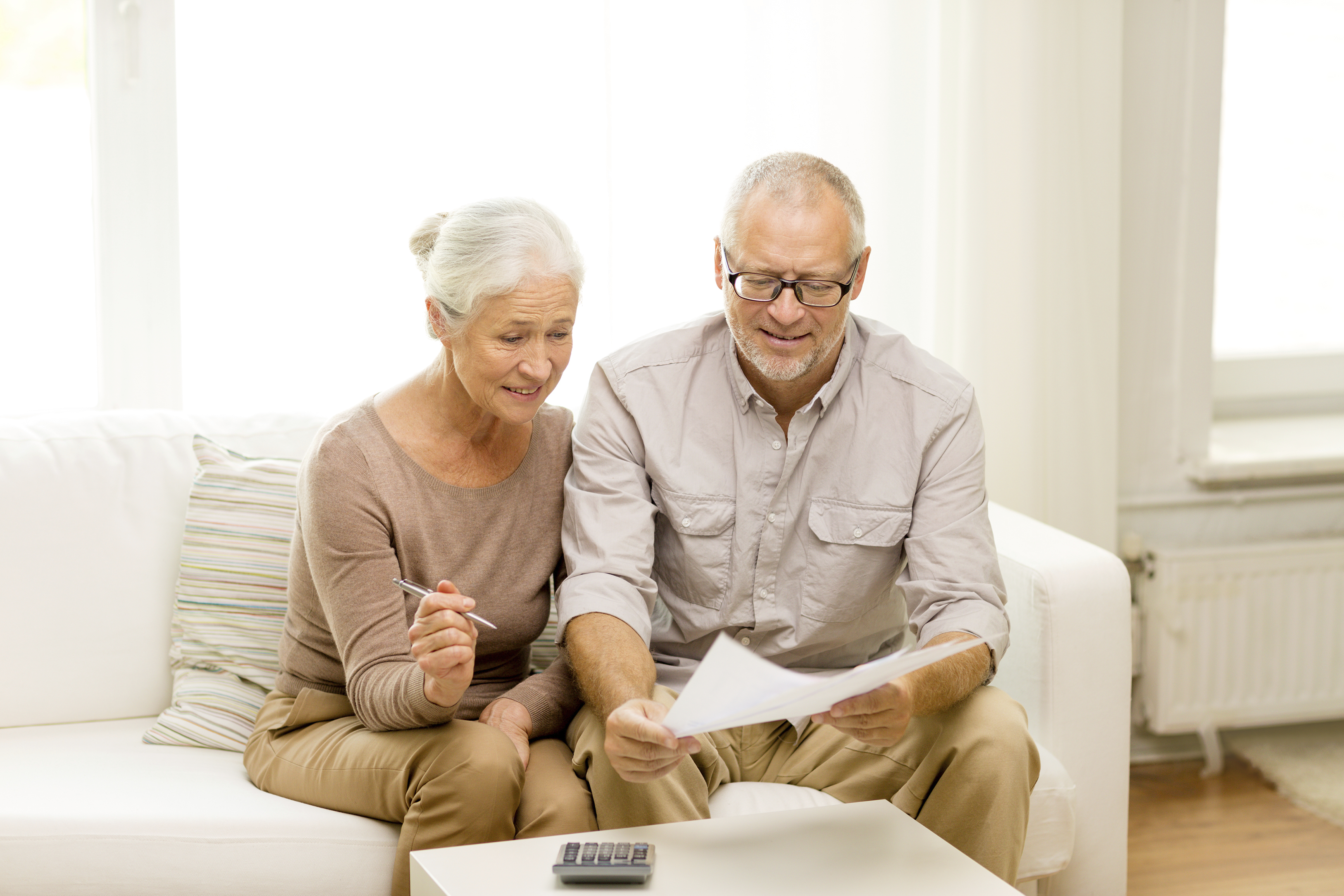 senior couple with papers and calculator at home