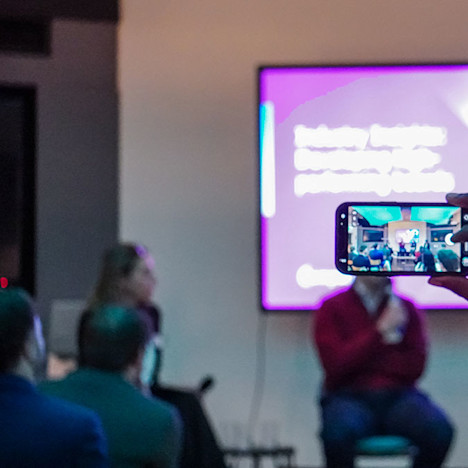 Someone takes a photo of the Industry Insights stage Tile image of Someone takes a photo of the Industry Insights stage