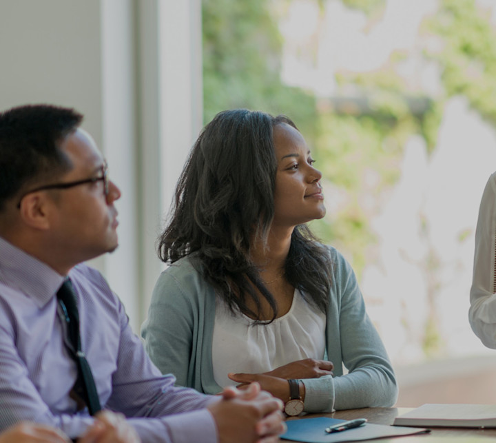 a group of young business professionals attending a presentation in a board room