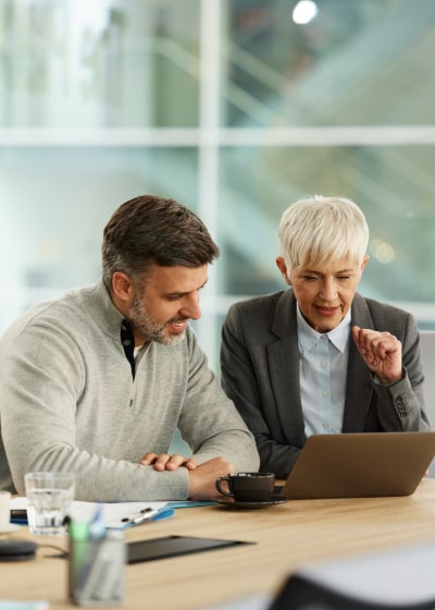 Corporate man and woman looking at laptop in meeting
