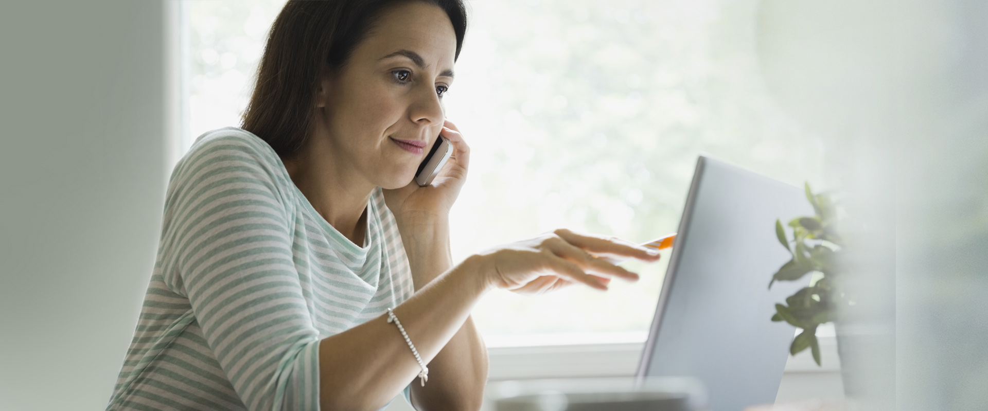 GettyImages-184829119-woman-on-phone-and-computer