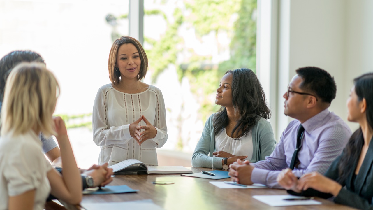 A group of young business professionals attending a presentation in a board room.