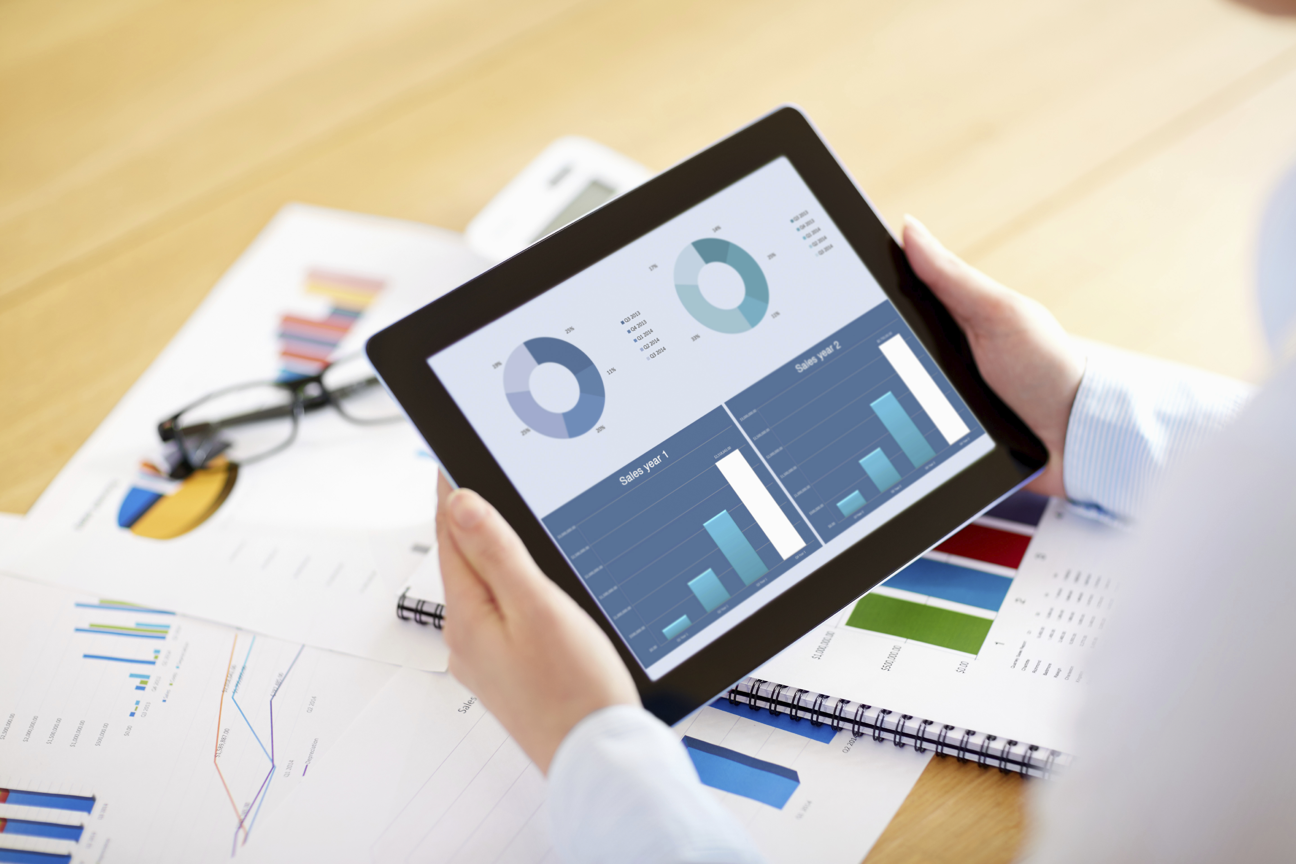 Businesswoman showing digital tablet comparing sales